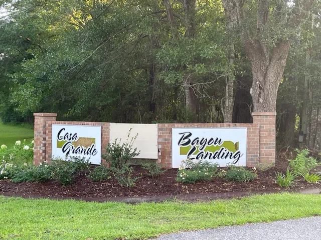 a sign that is sitting in front of a tree