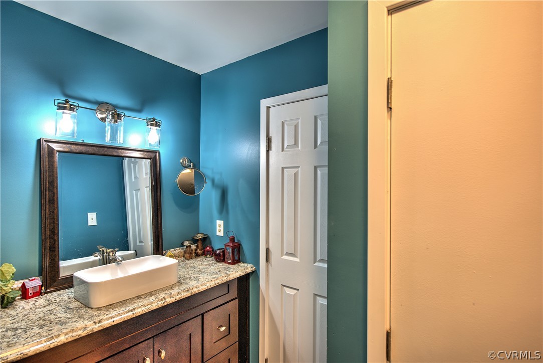 6440 Glebe Point Road Chesterfield, VA 23838 - Photo 21 of 24 a bathroom with a granite countertop sink and a mirror