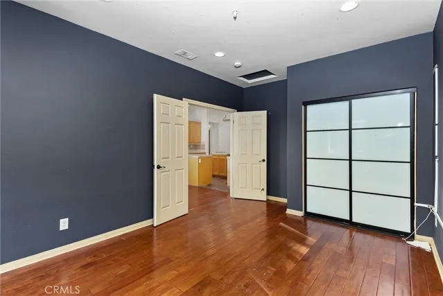 a view of a hallway with wooden floor and a chandelier