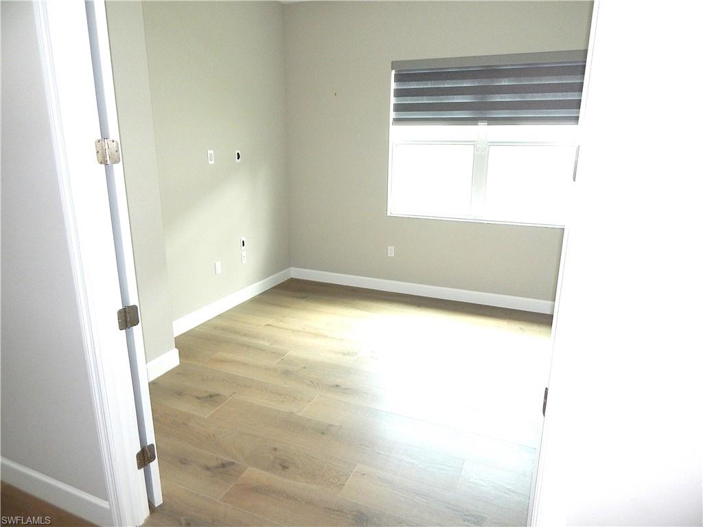 11331 Jacaranda Drive Naples, FL 34120 - Photo 17 of 47 Unfurnished room featuring wood finished floors and baseboards
