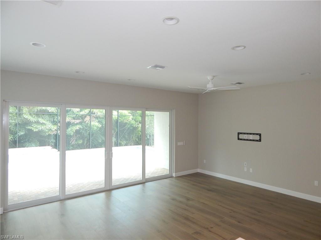 11331 Jacaranda Drive Naples, FL 34120 - Photo 19 of 47 Unfurnished room with baseboards, wood finished floors, a ceiling fan, and recessed lighting