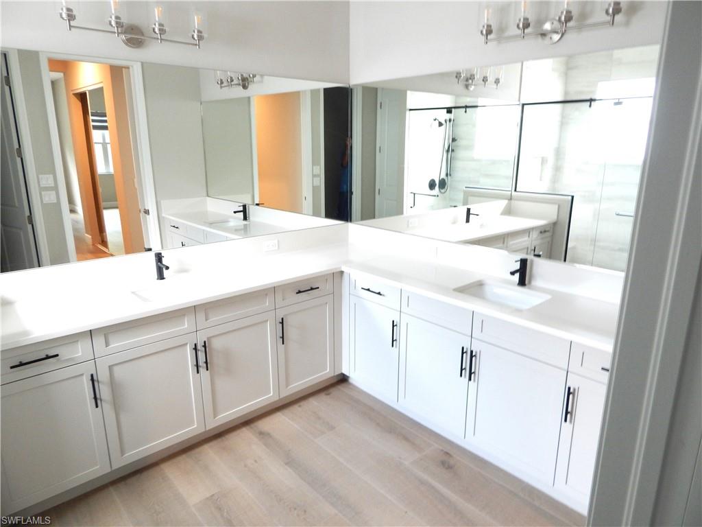 11331 Jacaranda Drive Naples, FL 34120 - Photo 21 of 47 Bathroom with wood finished floors, double vanity, and a shower with shower door
