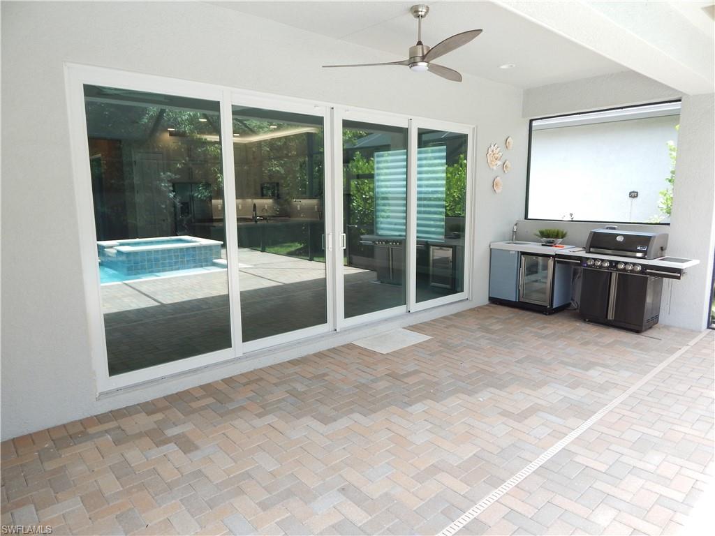 11331 Jacaranda Drive Naples, FL 34120 - Photo 29 of 47 View of patio featuring a ceiling fan, an in-ground hot tub, and a grill