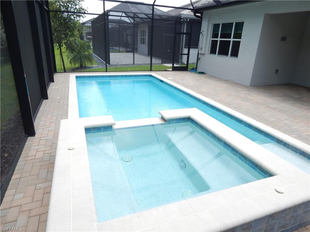 11331 Jacaranda Drive Naples, FL 34120 - Photo 3 of 47 View of pool with a patio area, a pool with connected hot tub, and glass enclosure