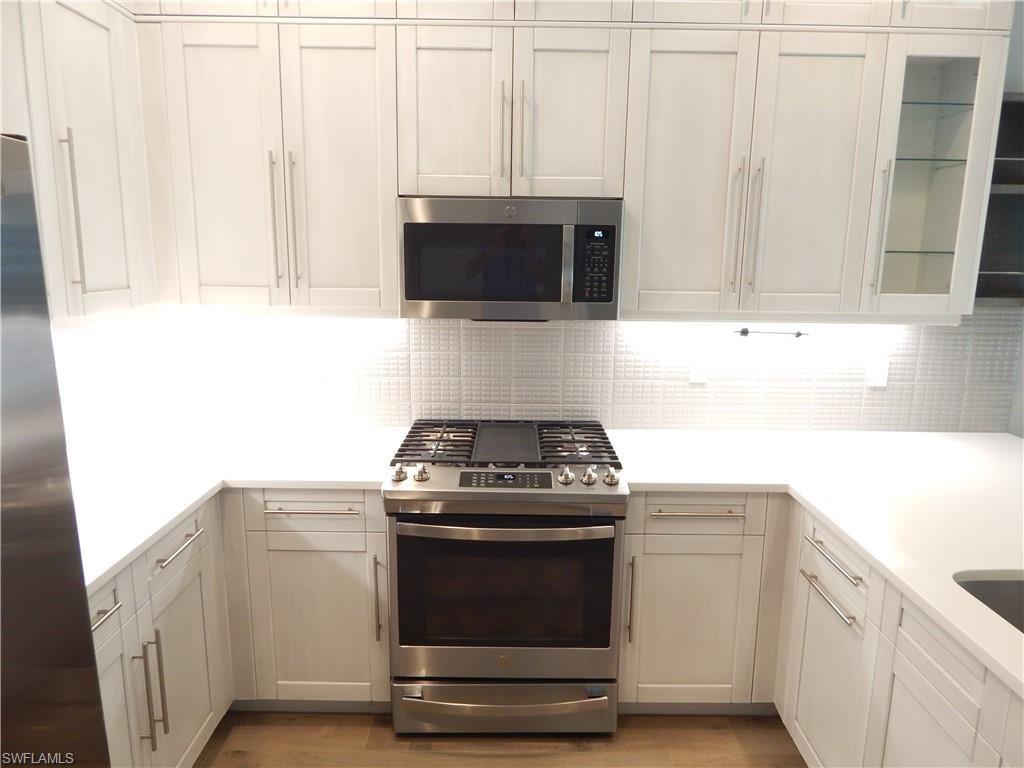 11331 Jacaranda Drive Naples, FL 34120 - Photo 10 of 47 Kitchen with appliances with stainless steel finishes, backsplash, and light countertops