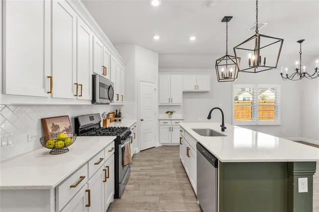 a kitchen with stainless steel appliances granite countertop a sink a stove and a wooden cabinets