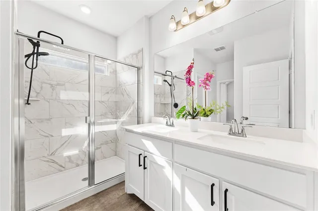 a bathroom with a granite countertop shower sink and mirror