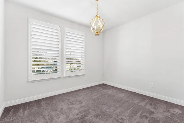 an empty room with a window and a chandelier