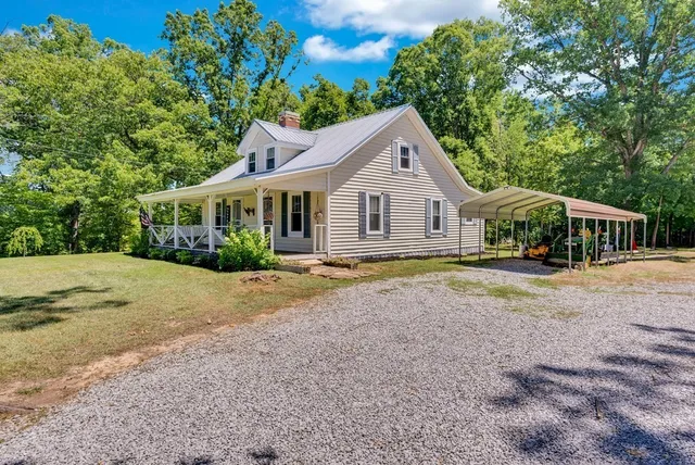 a front view of a house with a yard and potted plants
