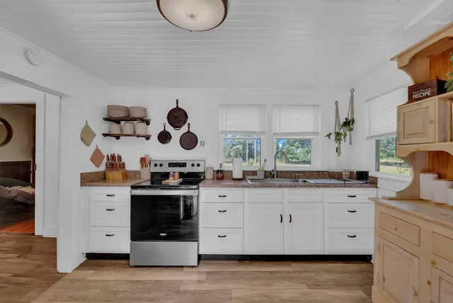 a kitchen with stainless steel appliances granite countertop a stove a sink and a large mirror