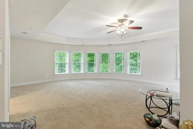 a view of an empty room with furniture and a window