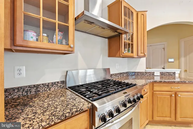 a kitchen with stainless steel appliances granite countertop a refrigerator and a stove top oven
