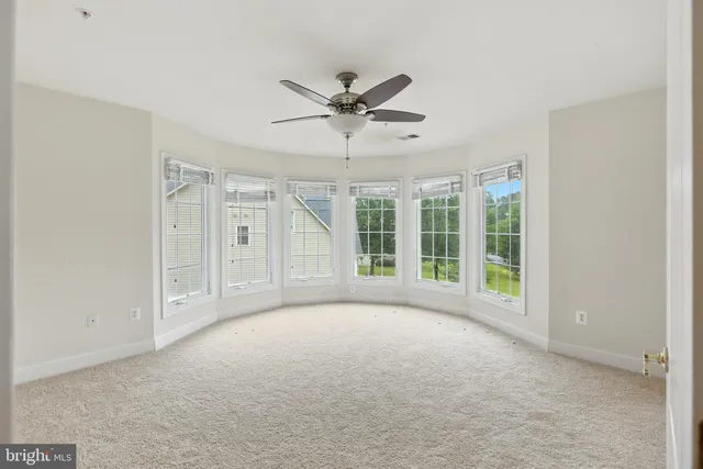 a view of a livingroom with a ceiling fan and window