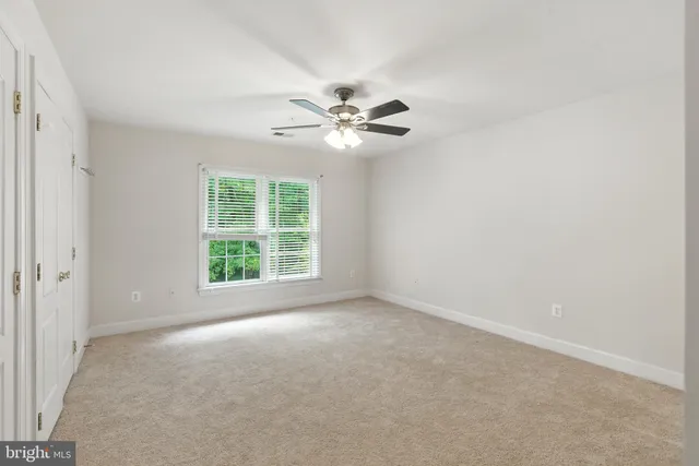 a view of a room with a ceiling fan and a window