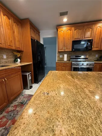 a kitchen with stainless steel appliances a refrigerator and a stove top oven