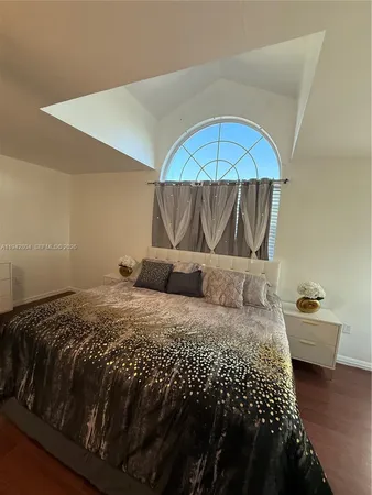 a living room with a bed furniture and a wooden floor
