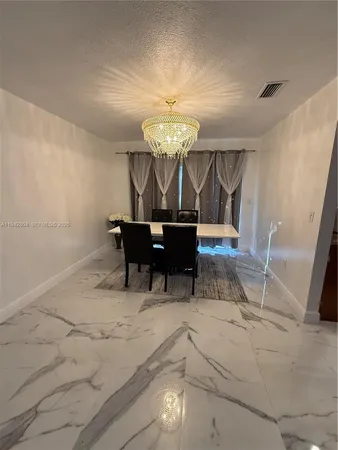 a view of a dining room with furniture and chandelier