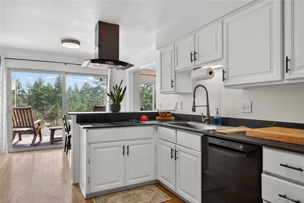 a kitchen with stainless steel appliances granite countertop a sink and white cabinets
