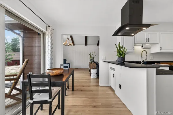 a kitchen with granite countertop kitchen island stainless steel appliances a table and chairs in it