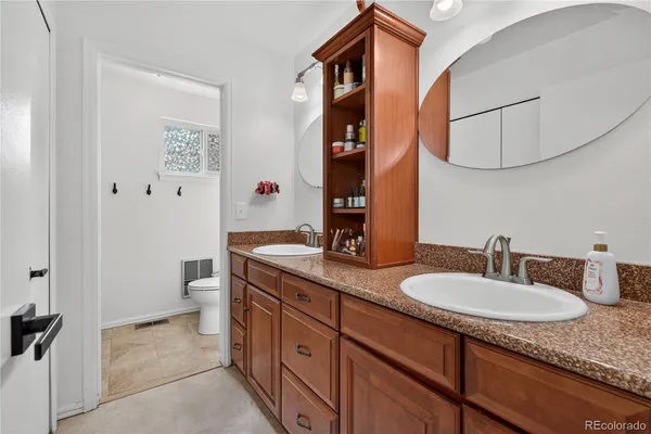 a bathroom with a granite countertop sink and a mirror