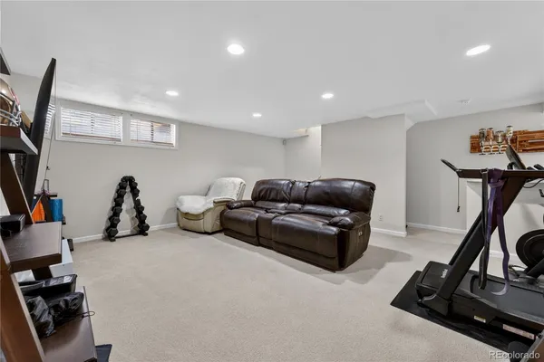 a living room with furniture a gym equipment and a flat screen tv