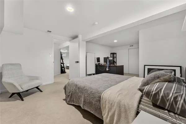 a spacious bedroom with a bed and a chair