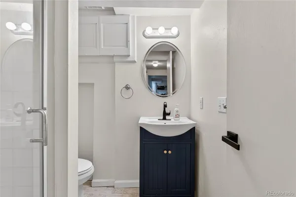 a bathroom with a sink a toilet and shower