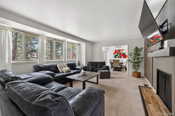a living room with furniture a fireplace and a large window