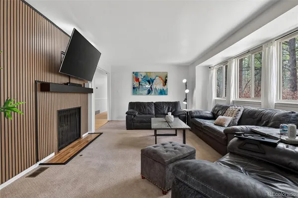 a living room with furniture a fireplace and a flat screen tv