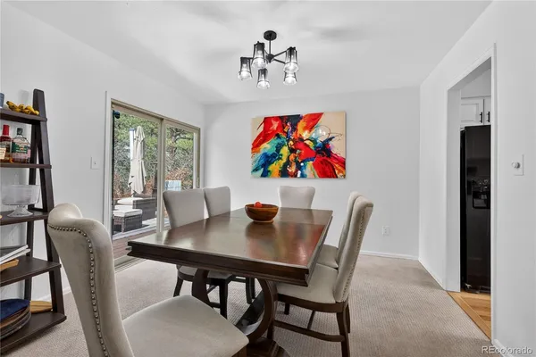 a view of a dining room with furniture a chandelier and wooden floor