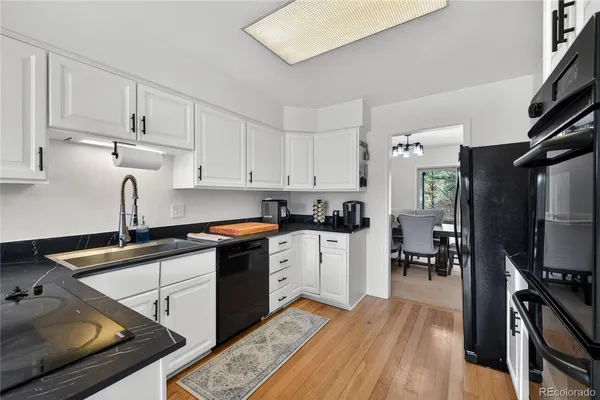 a kitchen with granite countertop a sink stove and cabinets