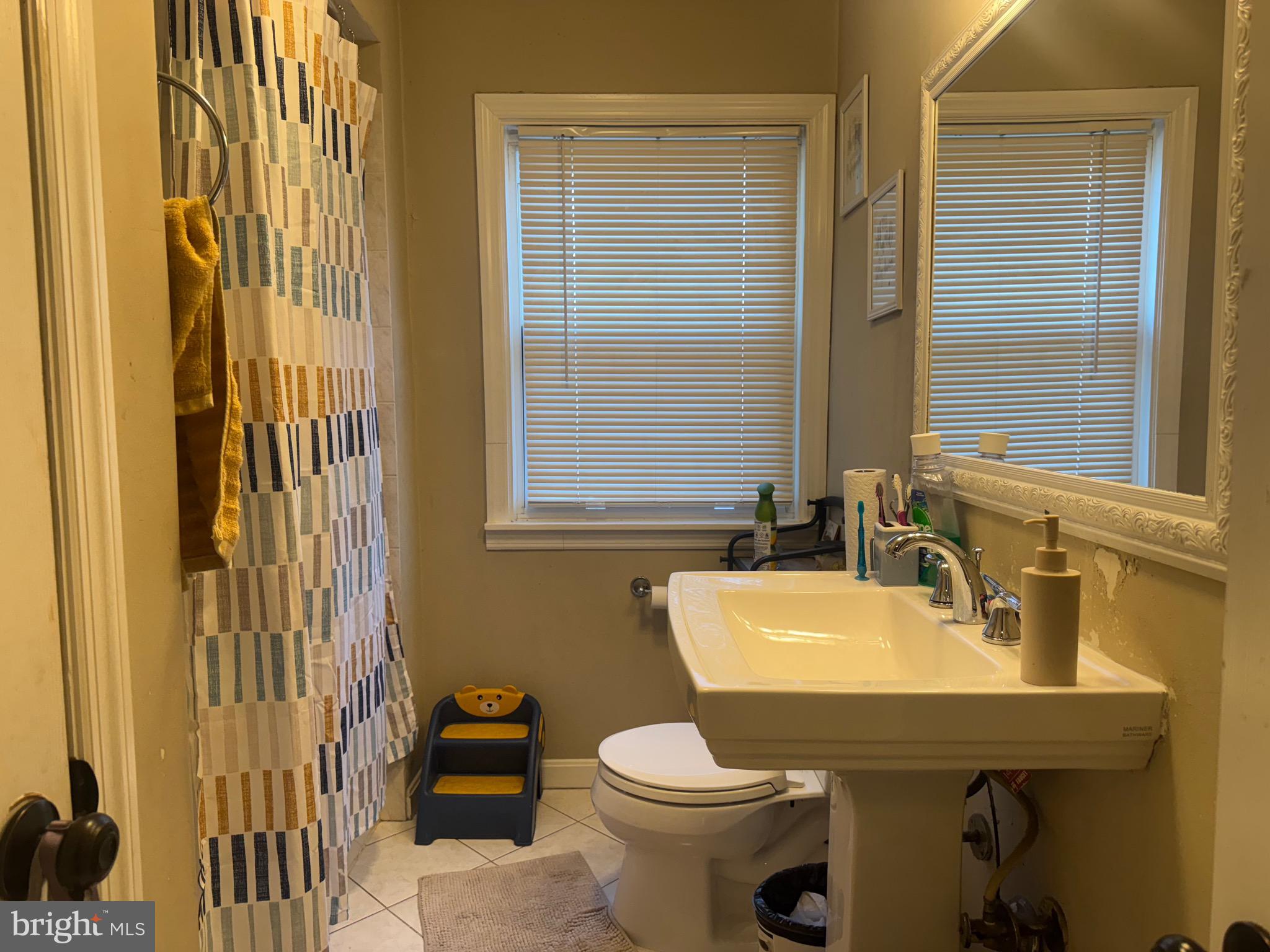 1653 Stonewood Road Baltimore, MD 21239 - Photo 11 of 17 a bathroom with a sink a toilet and shower curtain