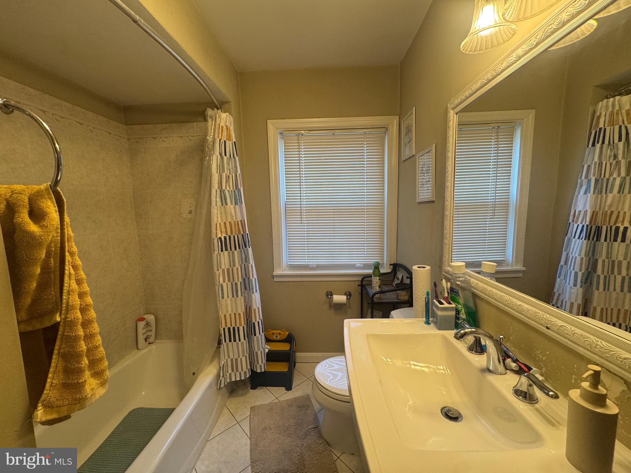 1653 Stonewood Road Baltimore, MD 21239 - Photo 12 of 17 a bathroom with a sink a tub and a mirror