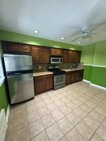 a kitchen with stainless steel appliances a refrigerator and a stove top oven