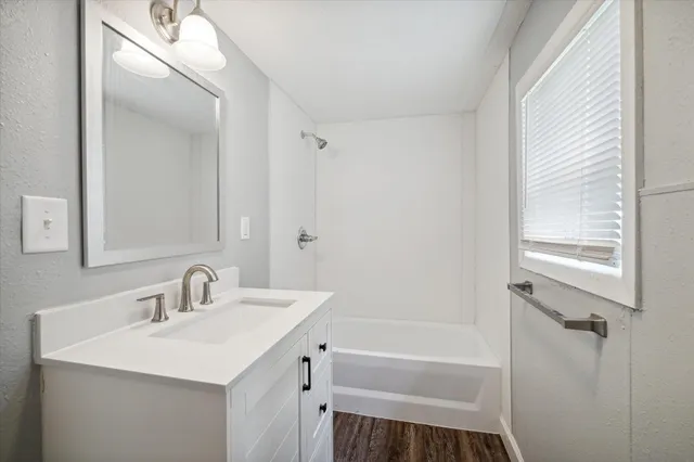 a bathroom with a sink mirror vanity and a bathtub