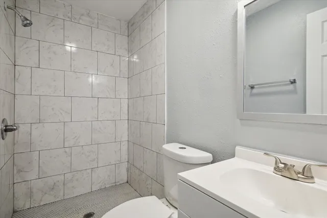 a bathroom with a sink toilet and shower