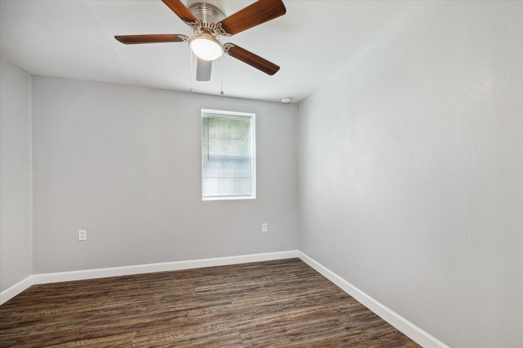 110 Maplewood Street Dayton, TX 77535 - Photo 10 of 12 an empty room with wooden floor ceiling fan and window