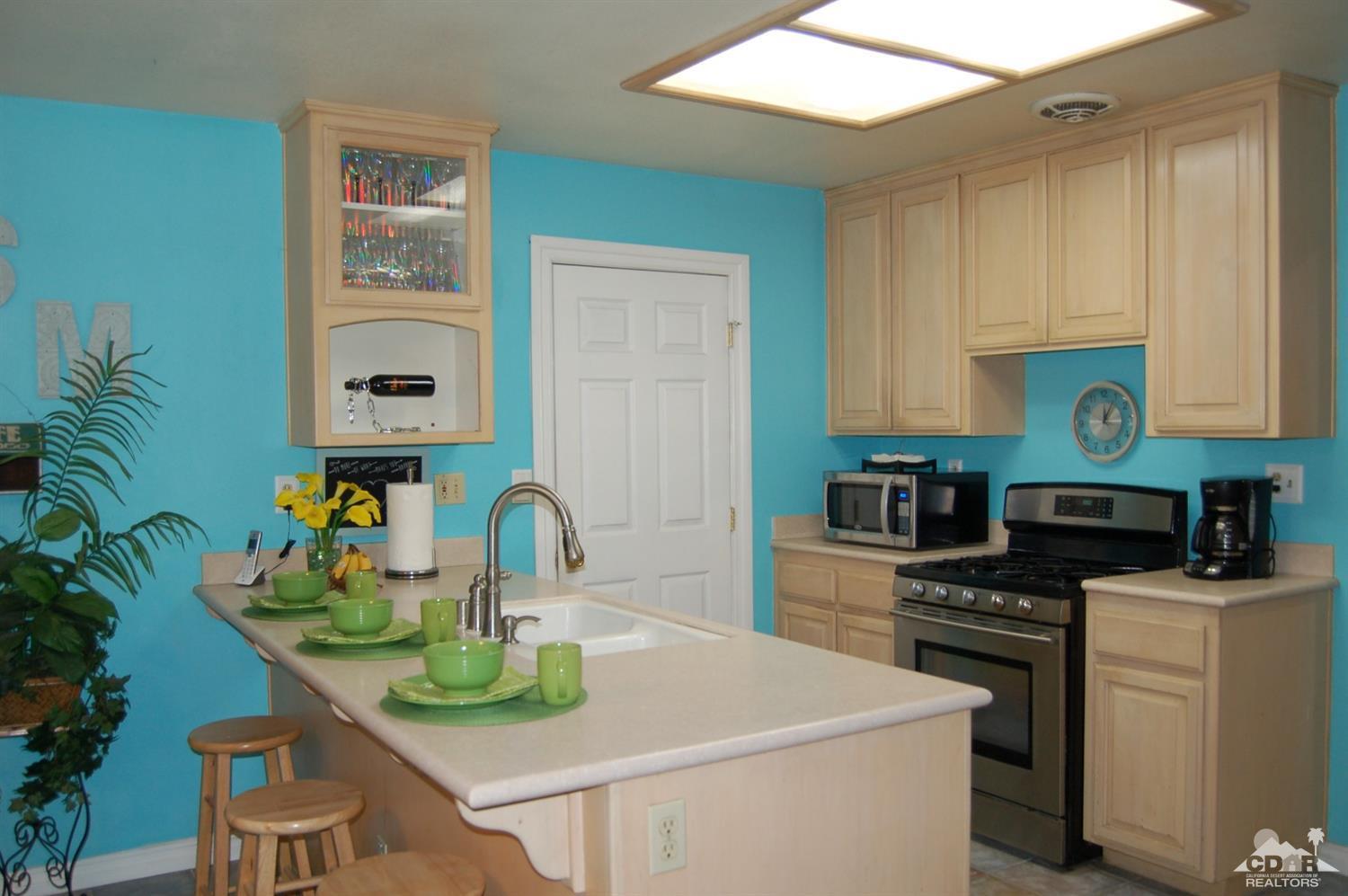 4591 Toyon Road Riverside, CA 92504 - Photo 20 of 40 a kitchen with stainless steel appliances kitchen island granite countertop a sink a stove and cabinets