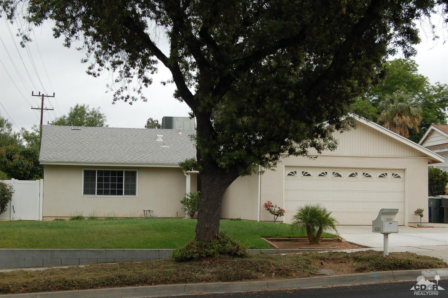 4591 Toyon Road Riverside, CA 92504 - Photo 26 of 40 a view of a white house next to a yard with plants and trees