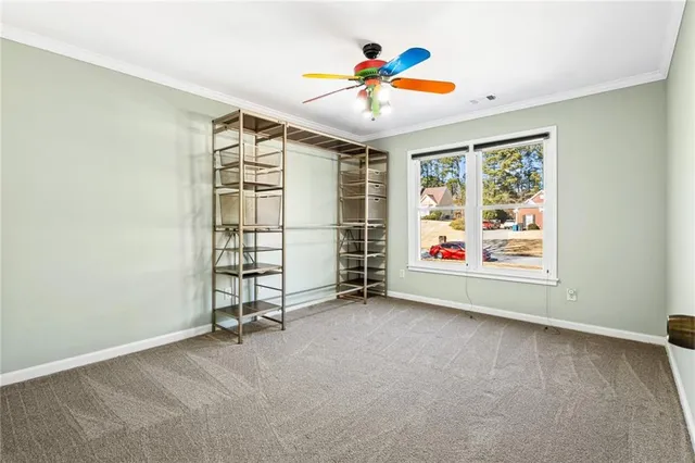 an empty room with window and ceiling fan