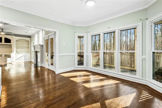 a view of a livingroom with wooden floor and large windows