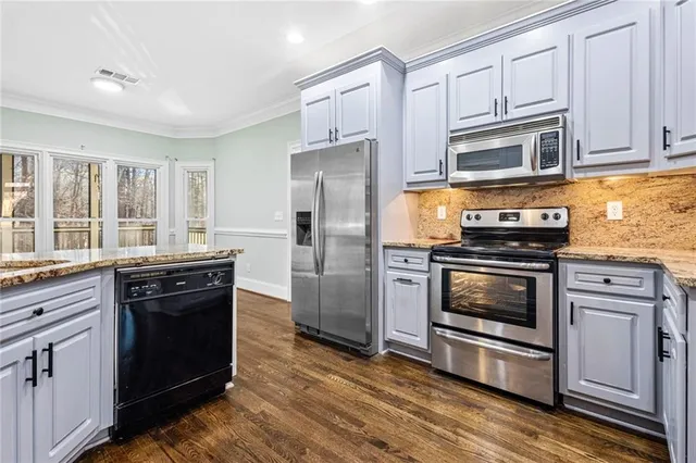 a kitchen with granite countertop a refrigerator stove and oven