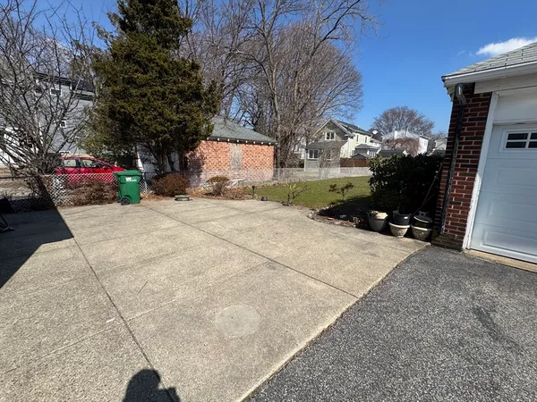 a front view of a house with a yard and a large tree