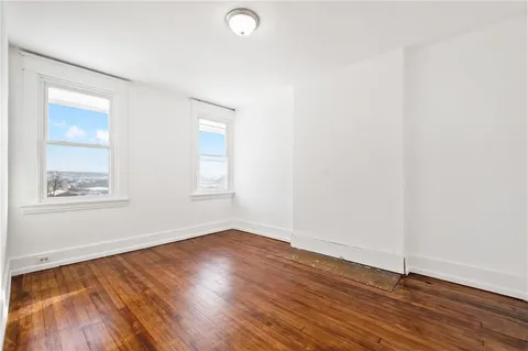 a view of a small space with wooden floor and a window