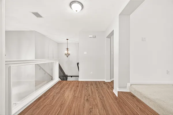 a view of empty room with wooden floor