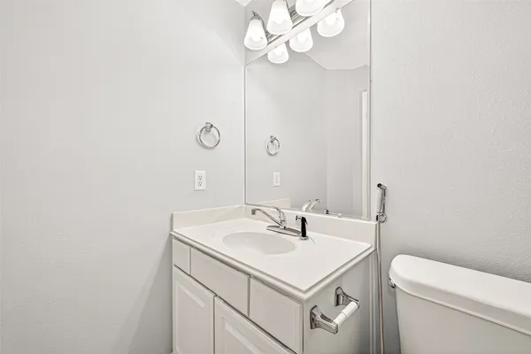 a bathroom with a sink a toilet and a mirror