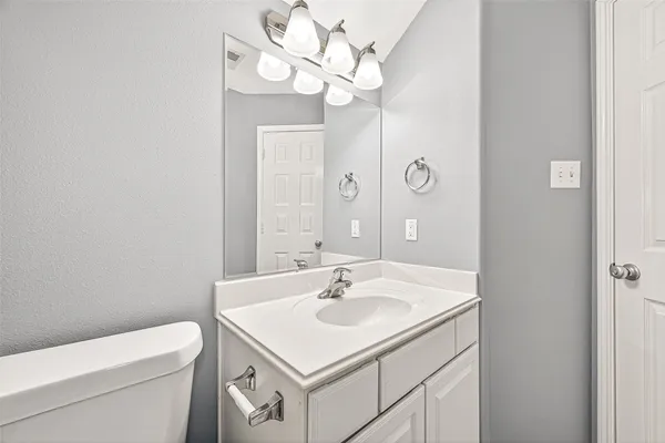 a bathroom with a sink a light fixture and a mirror