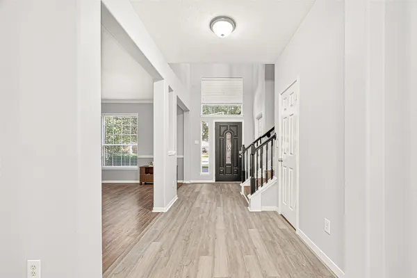 a view of hallway with wooden floor and stairs