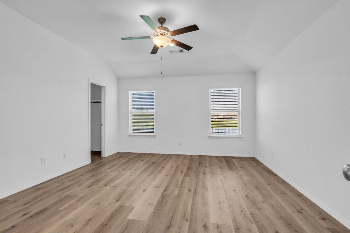 5402 Still Creek Ranch Drive Richmond, TX 77469 - Photo 21 of 32 an empty room with wooden floor ceiling fan and windows