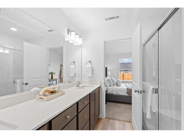 a en suite bathroom with a double vanity sink and a mirror